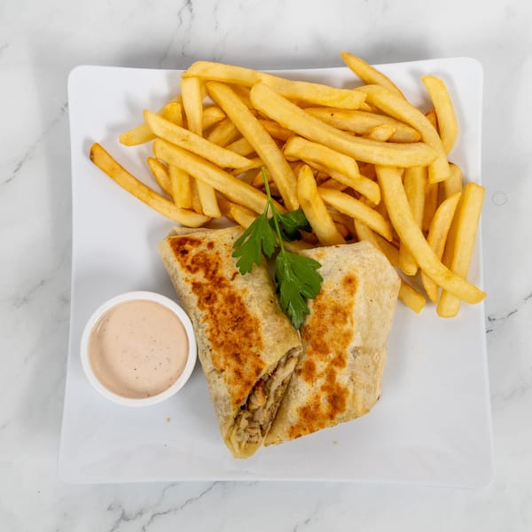 Two grilled wraps with a side of golden french fries and a small dish of dipping sauce.